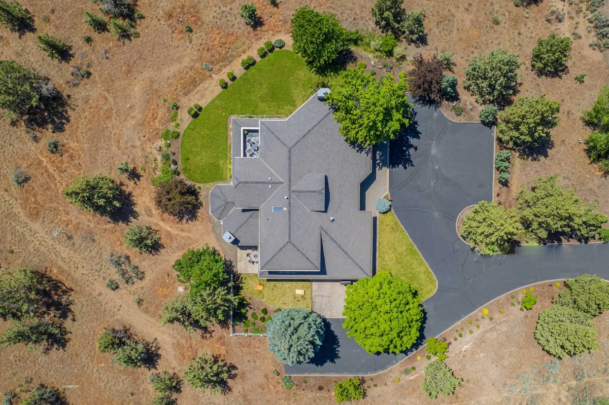 The exterior of a spacious home with a manicured lawn, trees, and a driveway—an inviting outdoor area well-suited for recreational activities like pickleball. The peaceful setting underscores the private, serene environment mentioned in the section.