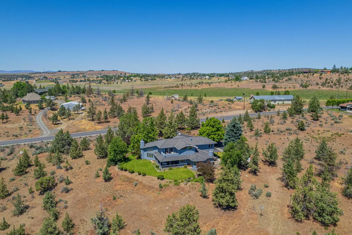 A spacious house set within a lush green lawn, surrounded by trees and open landscape. The peaceful setting suggests a home base for relaxation, wildlife observation, and launching into daily adventures.