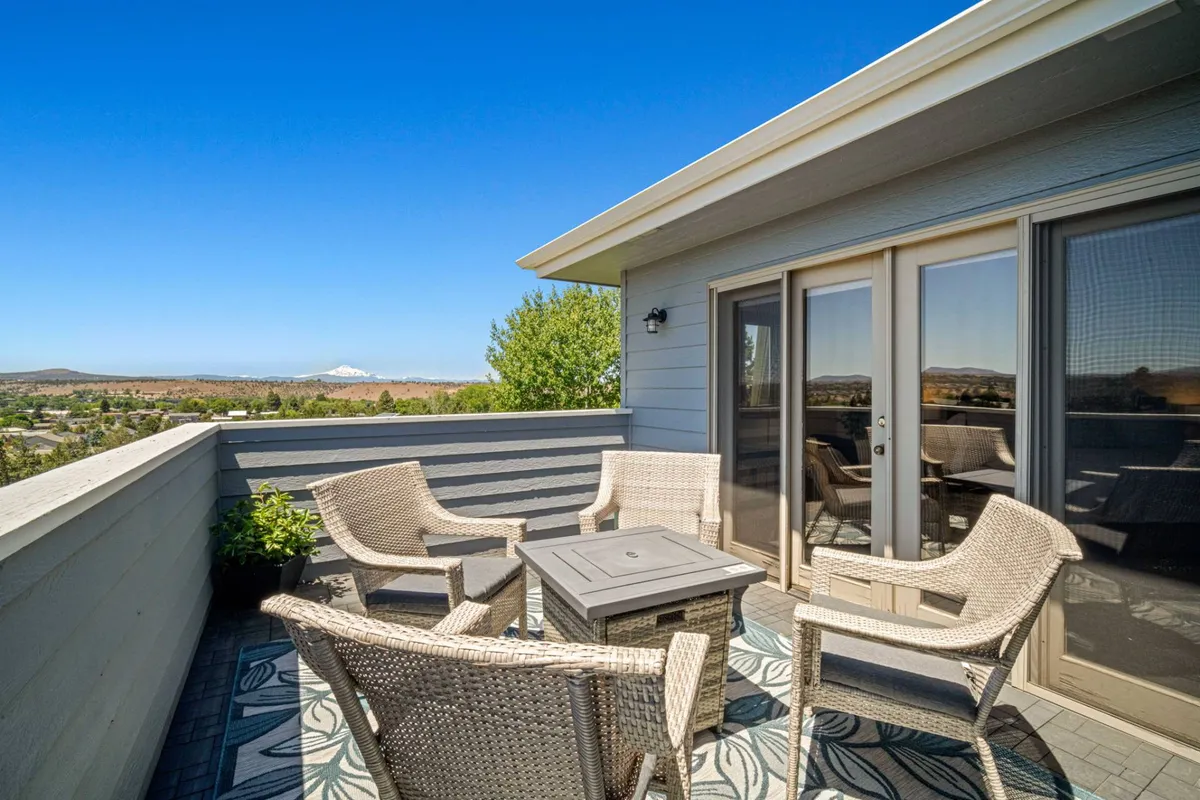 A tranquil outdoor seating area with a dining table is set against the backdrop of striking mountain views. The setup is inviting for group meals, socializing, or simply soaking in the scenery.
